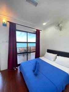 a bedroom with a blue bed with a view of the ocean at Perhentian Nemo Chalet in Perhentian Island
