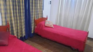 2 camas con colchas rojas en una habitación con cortinas en “Viví Mendoza” en Mendoza