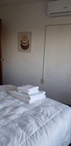 ein weißes Bett mit einem Haufen Handtücher drauf in der Unterkunft Frente a Terminal Tres Cruces. in Montevideo + 20 Fotos