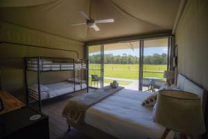 una camera con letto, ventilatore e finestra di Habitat Noosa a Cootharaba