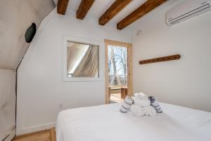 1 dormitorio con cama blanca y ventana en The Glamping Collective en Clyde