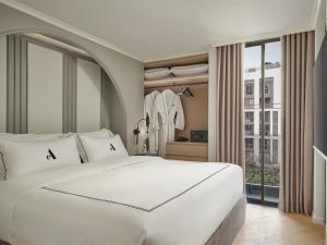 um quarto com uma grande cama branca e uma janela em The Alberti em Bangkok