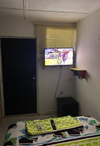 a room with a bed and a flat screen tv at Apartamento En Los Ángelesツ in Santa Marta