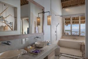 a bathroom with two sinks and a bath tub at Pramana Natura Nusa Penida in Nusa Penida