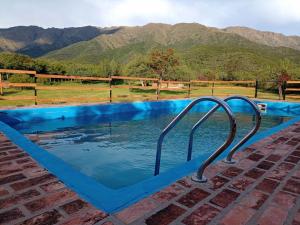 a swimming pool with a view of the mountains at BELLA VISTA CABAÑAS in Los Molles