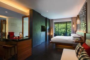 a bedroom with a bed and a desk and a room at Renaissance Bali Uluwatu Resort & Spa in Uluwatu