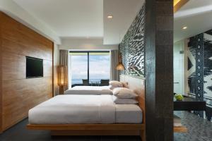 two beds in a hotel room with a view at Renaissance Bali Uluwatu Resort & Spa in Uluwatu
