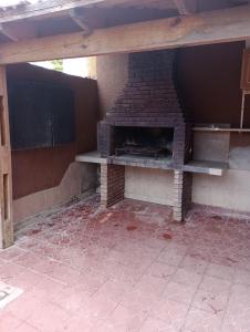 an outdoor brick fireplace in a room with a wall at Alojamiento mendoza in Las Heras