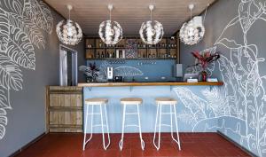 een keuken met een bar met krukken ervoor bij Blue Joys MSR in Siquijor
