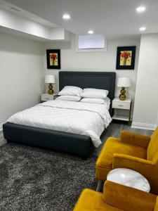 a bedroom with a large bed and a couch at New Luxurious Studio Apartment in Brampton