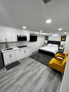 a living room with a bed and a kitchen at New Luxurious Studio Apartment in Brampton