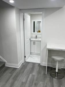 baño blanco con lavabo y escritorio en New Luxurious Studio Apartment, en Brampton