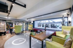 a living room with a table and yellow chairs at Viva Dash Hotel Seminyak in Seminyak