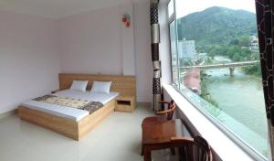 um quarto com uma cama e uma grande janela em Khách sạn Quý Anh - TT Bảo Lạc em Bảo Lạc