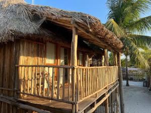 une petite cabane avec un toit de paille et un palmier dans l'établissement Xa am Natural Lodgement, à El Cuyo