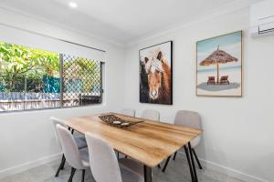 a dining room with a wooden table and chairs at Unit 2 11 Wentworth Avenue Nelson Bay in Nelson Bay