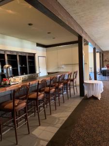 a kitchen with a bar with a row of chairs at Hotel Cowansville in Cowansville