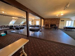 a large room with tables and chairs and a fireplace at Hotel Cowansville in Cowansville