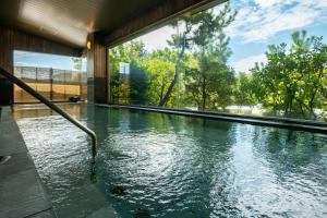 a swimming pool in a house with water at SHINGEN-no-Yu Yumura Onsen TOKIWA HOTEL in Kofu