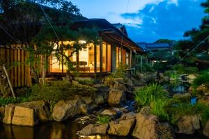 ein Haus mit einem Teich davor in der Unterkunft Tokiwa Hotel in Kofu