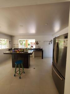 a kitchen with a stainless steel refrigerator and a stool at Casa vacacional Villavicencio Lacanti in Villavicencio