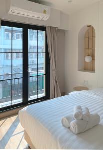 Moon House BKK Room 3A في بانغنا: غرفة نوم عليها سرير وفوط