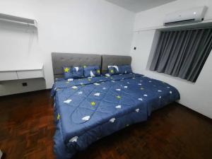 a bedroom with a bed with a blue comforter at XHQ Home stay - Bayview b-9-2 in Kampong Baharu