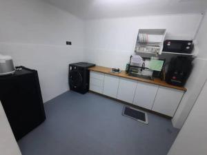 a room with a kitchen with a counter and a microwave at XHQ Home stay - Bayview b-9-2 in Kampong Baharu