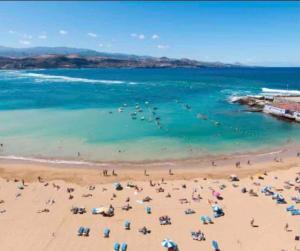 une plage avec beaucoup de gens dans l'eau dans l'établissement 2 Bedrooms Flat 50 mts away from Las Canteras beach, à Las Palmas de Gran Canaria