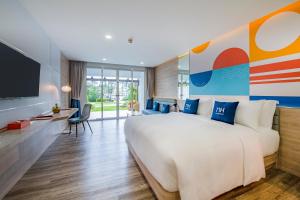 a bedroom with a large bed and a tv at NH Boat Lagoon Phuket Resort in Phuket