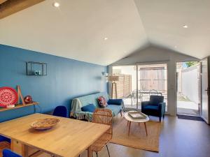 een woonkamer met een houten tafel en blauwe muren bij Maison Aytré, 2 pièces, 4 personnes - FR-1-710-12 in Aytré
