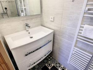 een witte badkamer met een wastafel en een spiegel bij Maison Aytré, 2 pièces, 4 personnes - FR-1-710-12 in Aytré