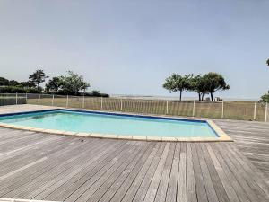 uma piscina num deque de madeira com o oceano ao fundo em Appartement Châtelaillon-Plage, 3 pièces, 3 personnes - FR-1-710-21 em Châtelaillon-Plage