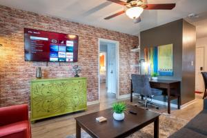 uma sala de estar com uma parede de tijolos em Trendy Escape ◉ California King bed awaits! em Charlotte