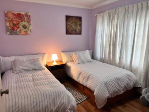 1 dormitorio con 2 camas y mesa con lámpara en MountForest en Shoreline