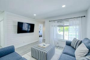 a living room with a blue couch and a tv at Blue Cove in Deerfield Beach