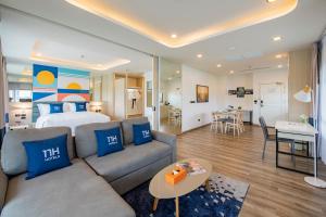 a living room with a couch and a bed in a room at NH Boat Lagoon Phuket Resort in Phuket