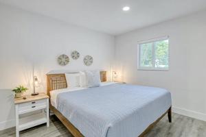 a white bedroom with a large bed and a window at Blue Cove in Deerfield Beach