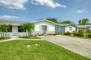 a house with a yard with a driveway at Blue Cove in Deerfield Beach