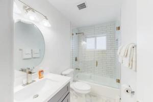 a white bathroom with a sink toilet and a mirror at Blue Cove in Deerfield Beach +28 photos