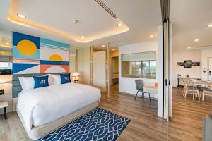 a bedroom with a bed and a dining room at NH Boat Lagoon Phuket Resort in Phuket Town
