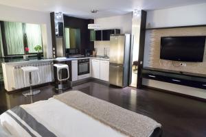a large kitchen with a refrigerator and a tv at Sector 6 - Metrou Gorjului - Studio G by MRG Apartments in Bucharest