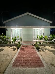 dom z ceglanym chodnikiem przed nim w obiekcie Chantara Cottage w mieście Kampung Mawar
