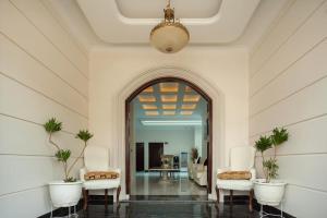 vestíbulo con sillas, mesa y lámpara de araña en Bethara Hotel Syariah Lampung en Tanjungkarang