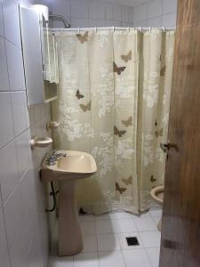 baño con cortina de ducha con pájaros en Departamento Pascual Toso en Villa Nueva