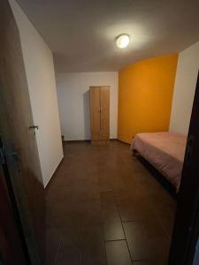 Habitación vacía con cama y armario de madera. en Departamento Pascual Toso en Villa Nueva