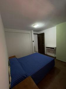 1 dormitorio con 1 cama azul en una habitación en Departamento Pascual Toso en Villa Nueva