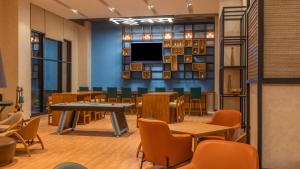 a waiting room with tables and chairs and a tv at ibis Thane - An Accor Brand in Thane