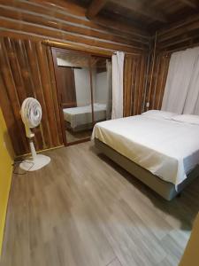 1 dormitorio con cama, ventilador y espejo en Hostal Fara en Jama