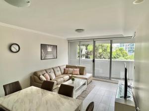 a living room with a couch and a table at Charming One-Bed Apt in the Heart of Parramatta in Sydney